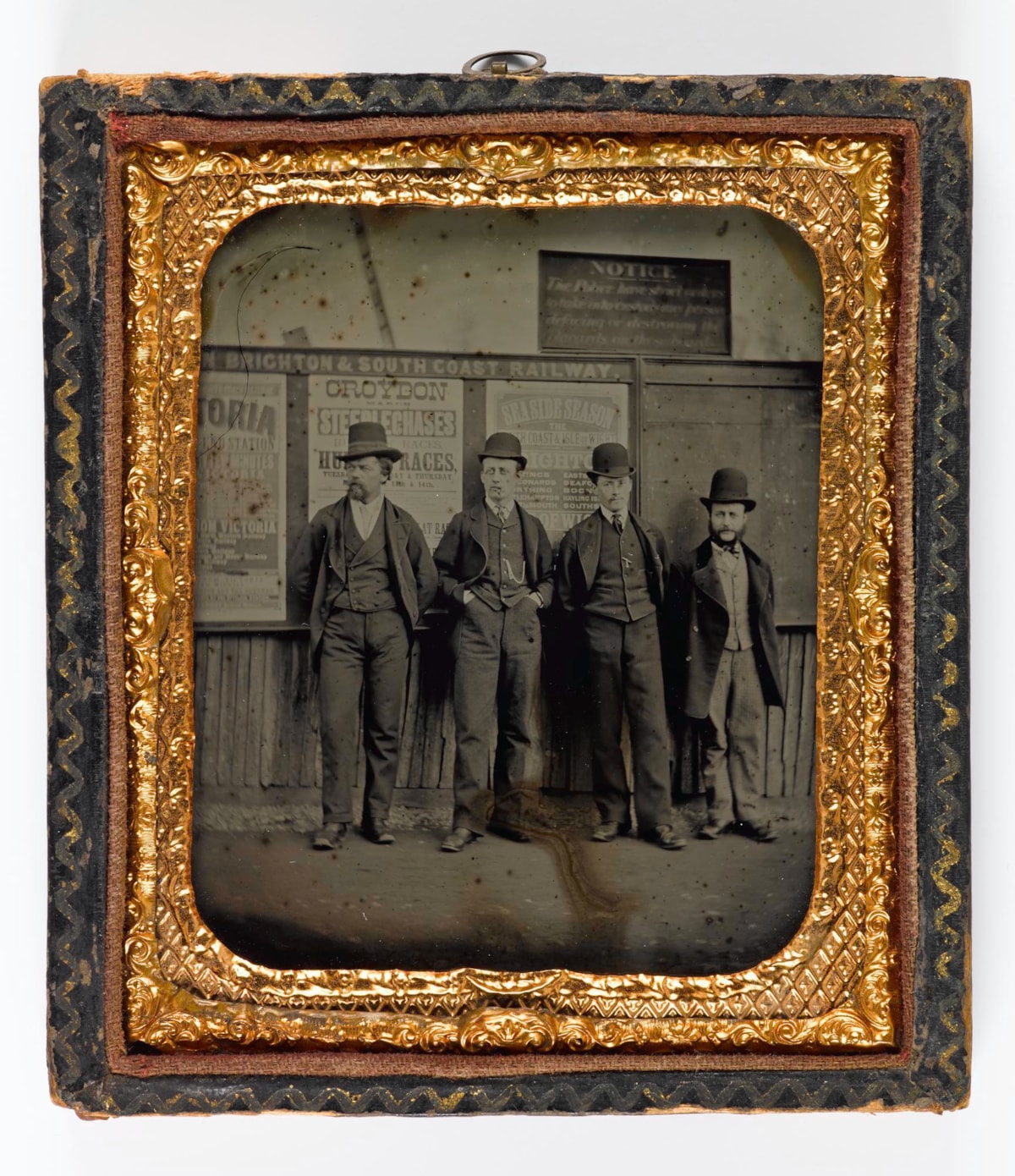 Ambrotype depicting four men wearing hats, waiting for the pub to open on a Sunday morning, by an unknown photographer, 1877