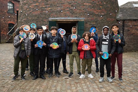 Pupils from Abraham Moss Community School in Manchester with decorative plates at Gladstone Pottery Museum in Stoke-on-Trent