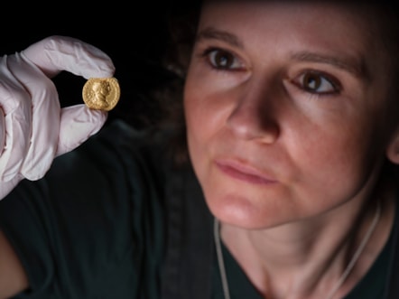 Conservator Bethan Bryan examines the gold Aureus of Trajan. Image © National Museums Scotland (3)
