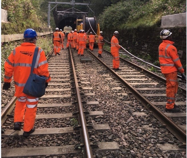 Train services resume on the Preston-Bolton-Manchester railway as upgrade nears completion: Team Orange installing power cables to supply new overhead equipment with electricity