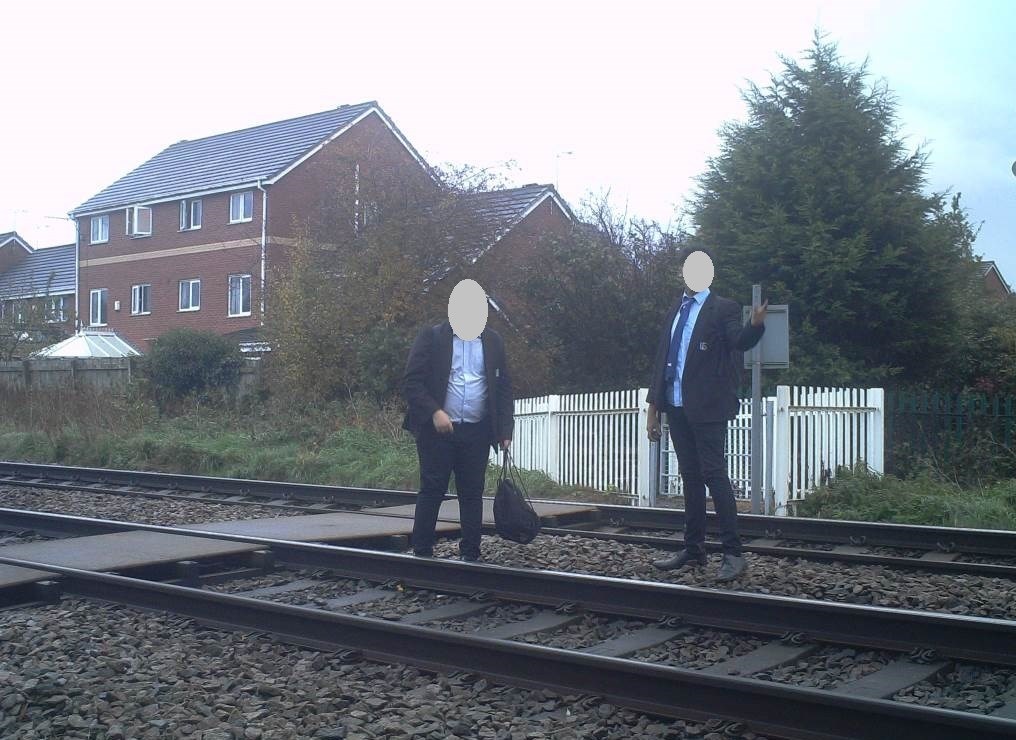Two schoolboys wonder down the track at a level crossing at Stapeley