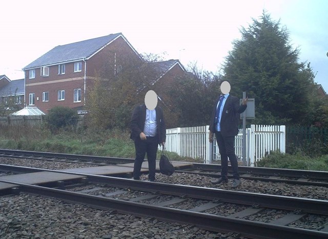 Two schoolboys wonder down the track at a level crossing at Stapeley