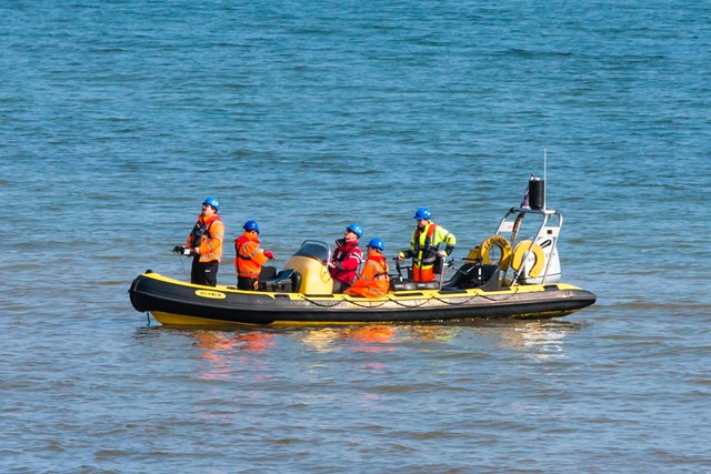 Crew in RIB with UAV 1: Unmanned Aerial Vehicle (UAV) being launched from a Rigid Inflatable Boat (RIB) at Teignmouth as part of a geological survey to improve the resilience of the railway between Exeter and Newton Abbot