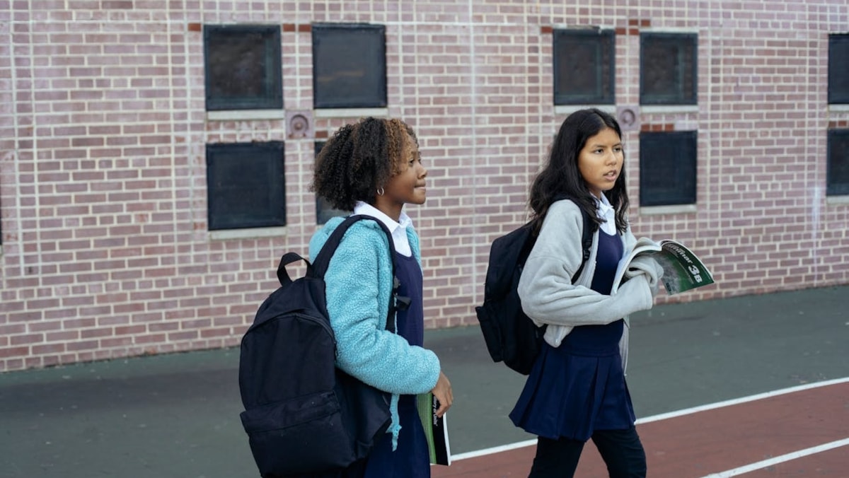 Two girls walking to school cropped-2