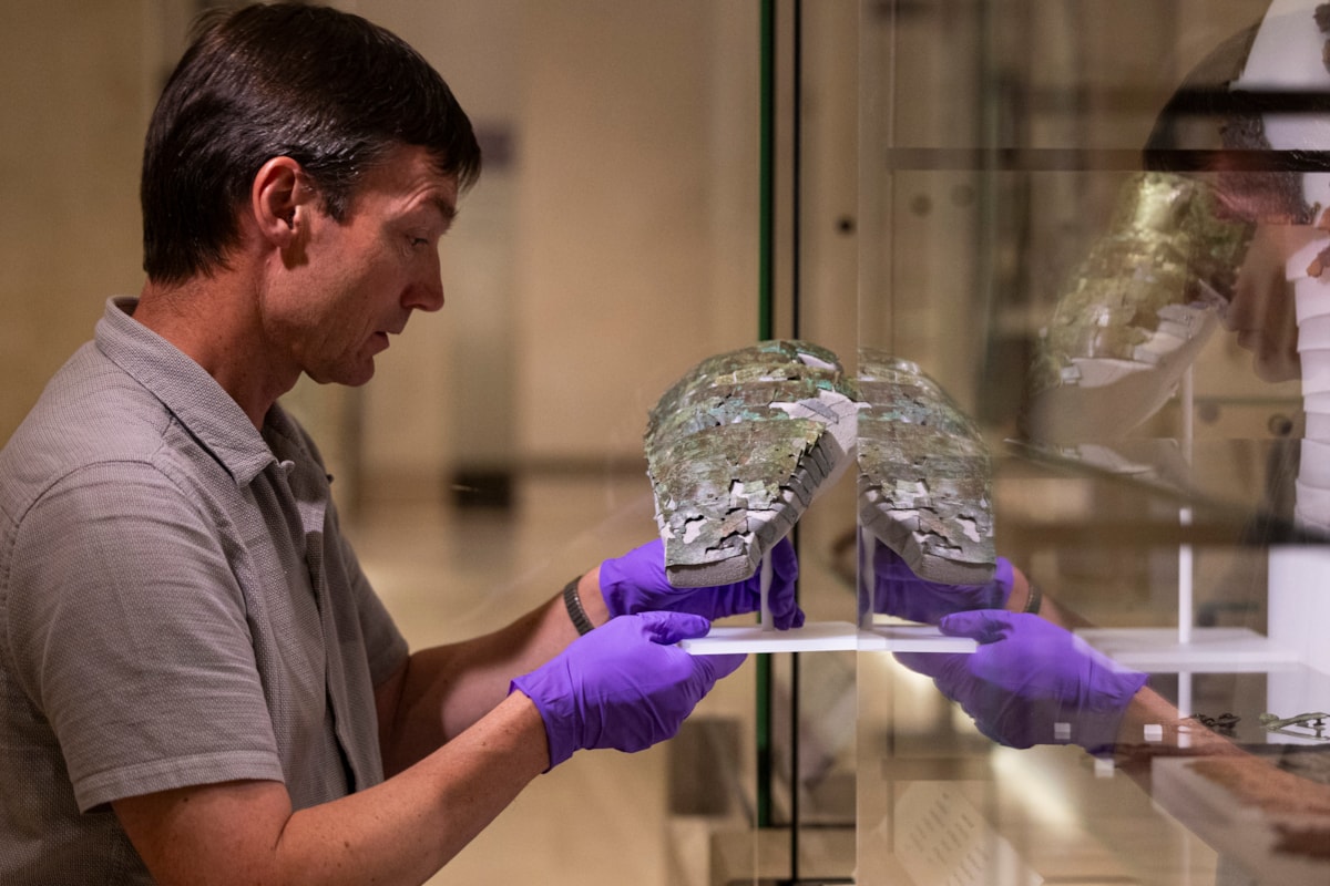 Dr Fraser Hunter installs the Roman arm guard in the Early People gallery at the National Museum of Scoltand. Image copyright Duncan McGlynn (9)