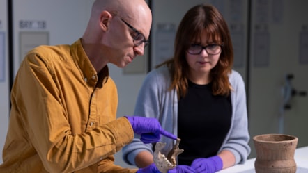 National Museums Scotland curators Dr Matthew Knight and Bethany Simpson examine archaeological human remains. Photo © Duncan McGlynn