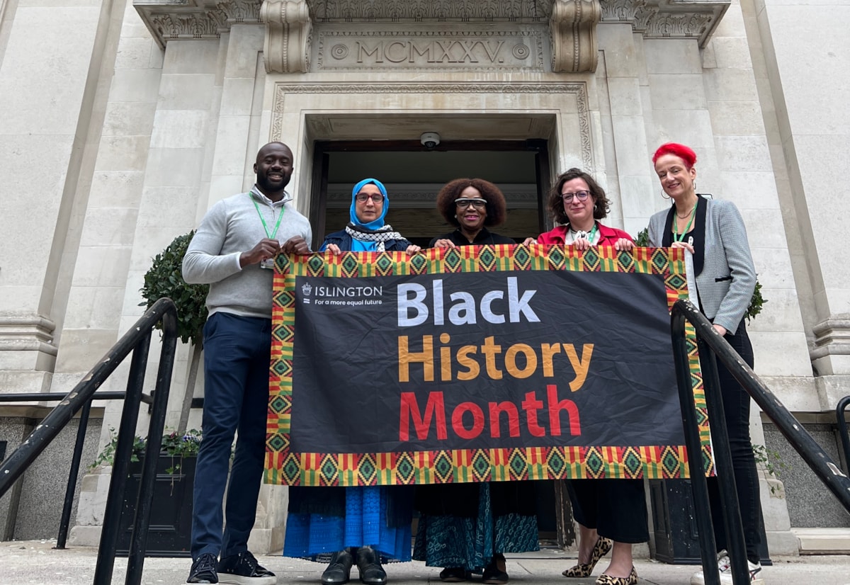 Councillors pose with the Black History Month flag outside Islington Town Hall