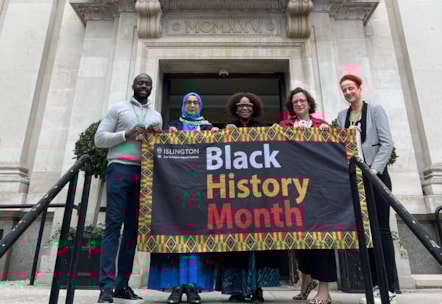 Councillors pose with the Black History Month flag outside Islington Town Hall