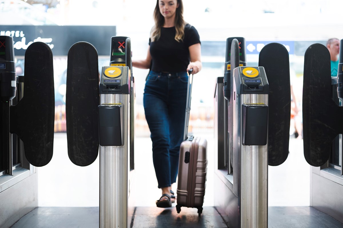 photo - Woman walking through ticket barrier