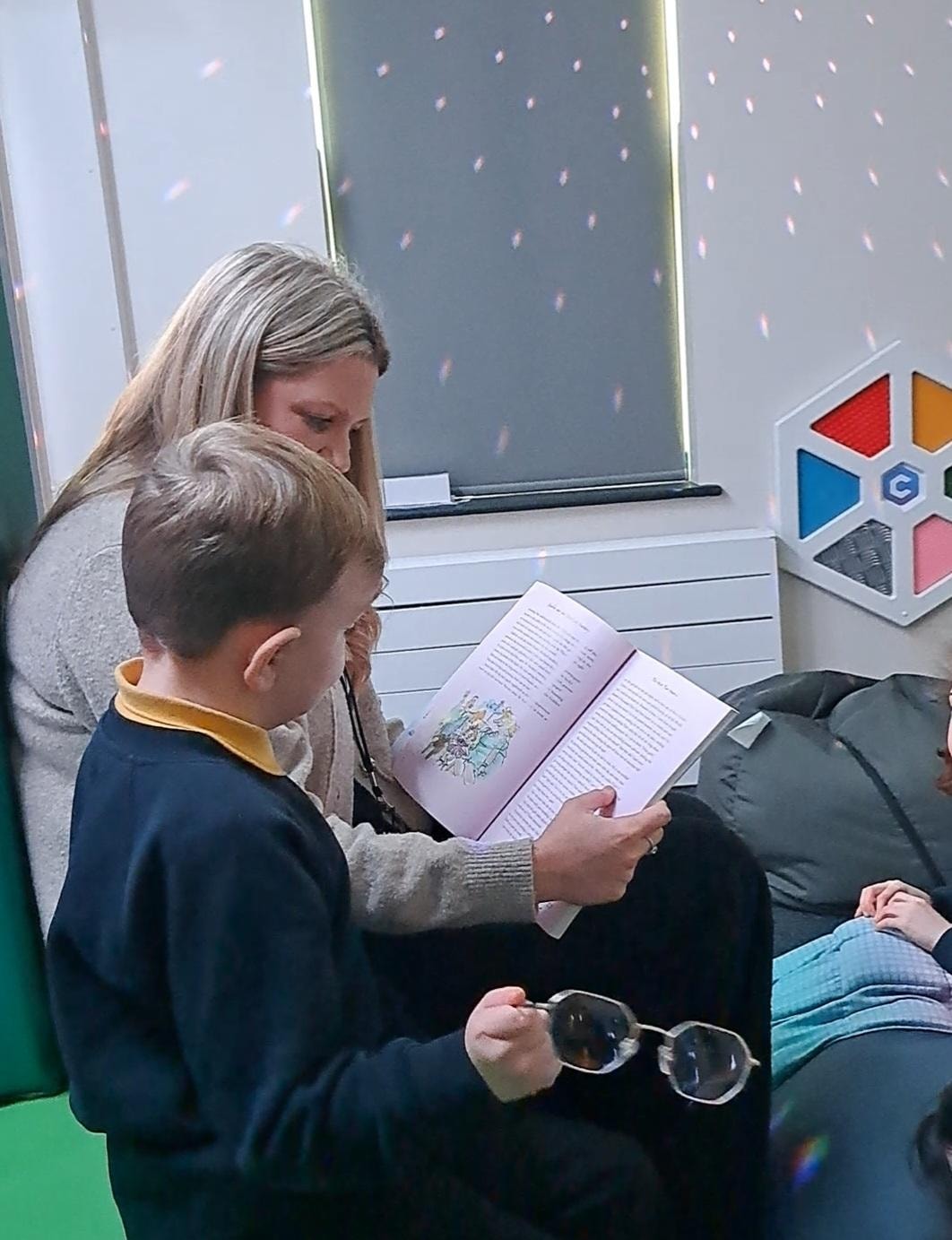 Teacher Sam Gardner reads a story to pupil Thomas at the Orchard, a new SEND unit at Thornton Primary School