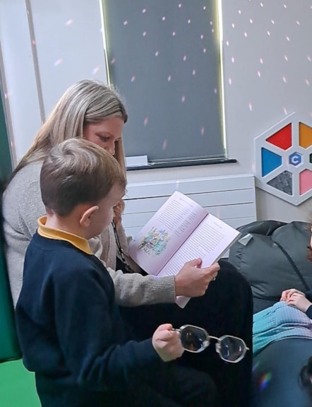 Teacher Sam Gardner reads a story to pupil Thomas at the Orchard, a new SEND unit at Thornton Primary School