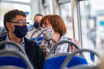 Couple on Bluestar bus wearing face coverings: With face masks