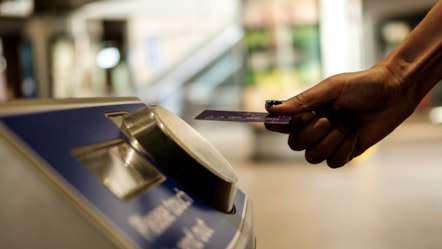 Person using TfL contactless reader with bank card