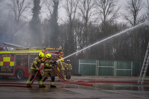 Find out if you have what it takes to become a firefighter: Firefighters training with a hose