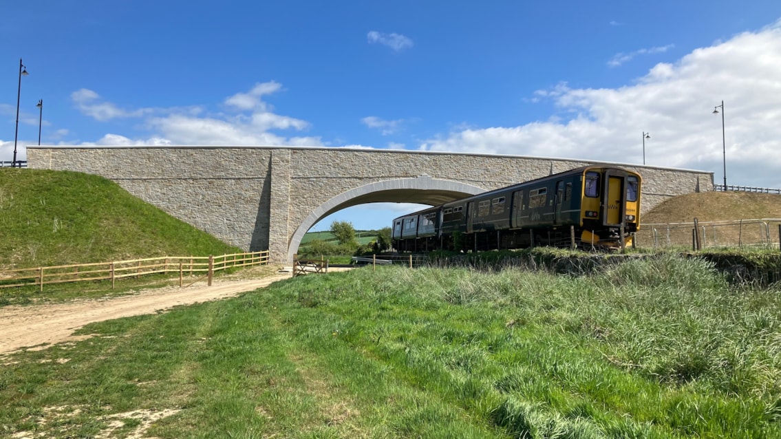 Newquay Strategic Route opens with Network Rail bridge now in use: GWR train passing under Nansledan bridge