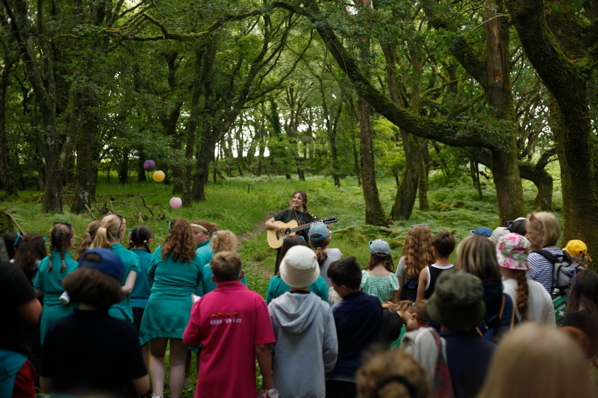 Mari Mathias yn perfformio yn y coed