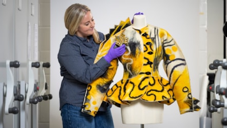 Curator Lisa Mason examines a yellow jacked designed by Jean Muir. Photo © Duncan McGlynn (2)
