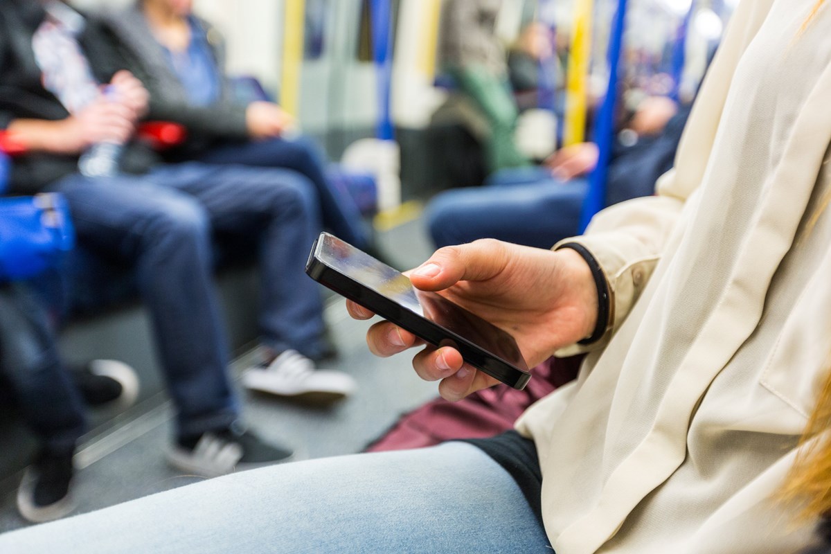 Passenger using his mobile phone on the tube