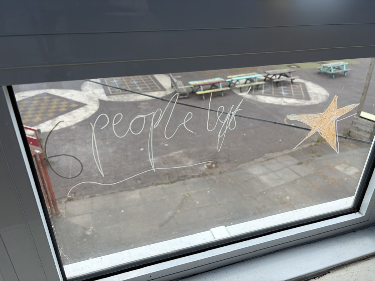 A view from a window in one of the Oldhill classrooms overlooking an outdoor playground, with the words '6 people left' and a drawing of a star