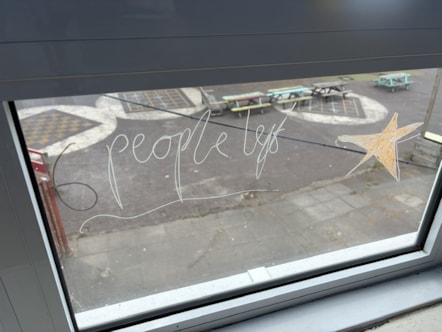 A view from a window in one of the Oldhill classrooms overlooking an outdoor playground, with the words '6 people left' and a drawing of a star