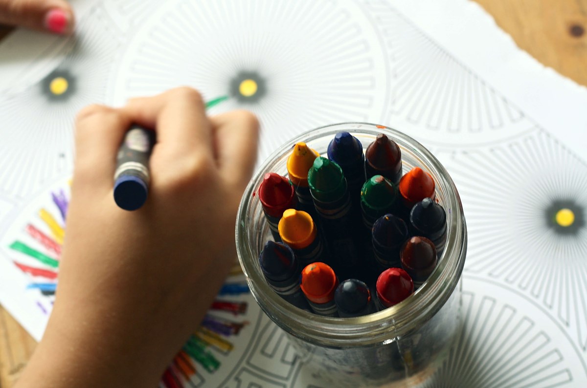 Child's hand holding crayons