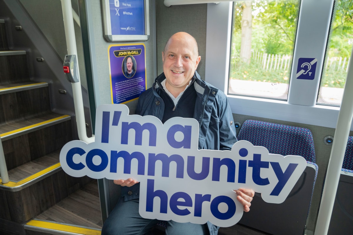 John McGall inside bus with plaque in his name