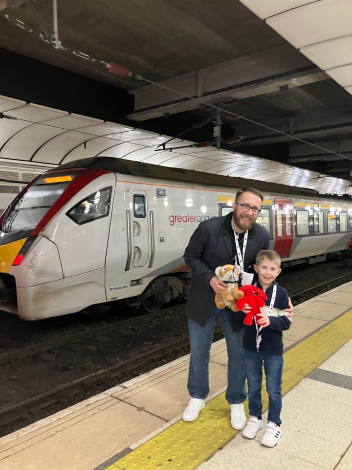 Austin, his dad and friends in front of a Greater Anglia train