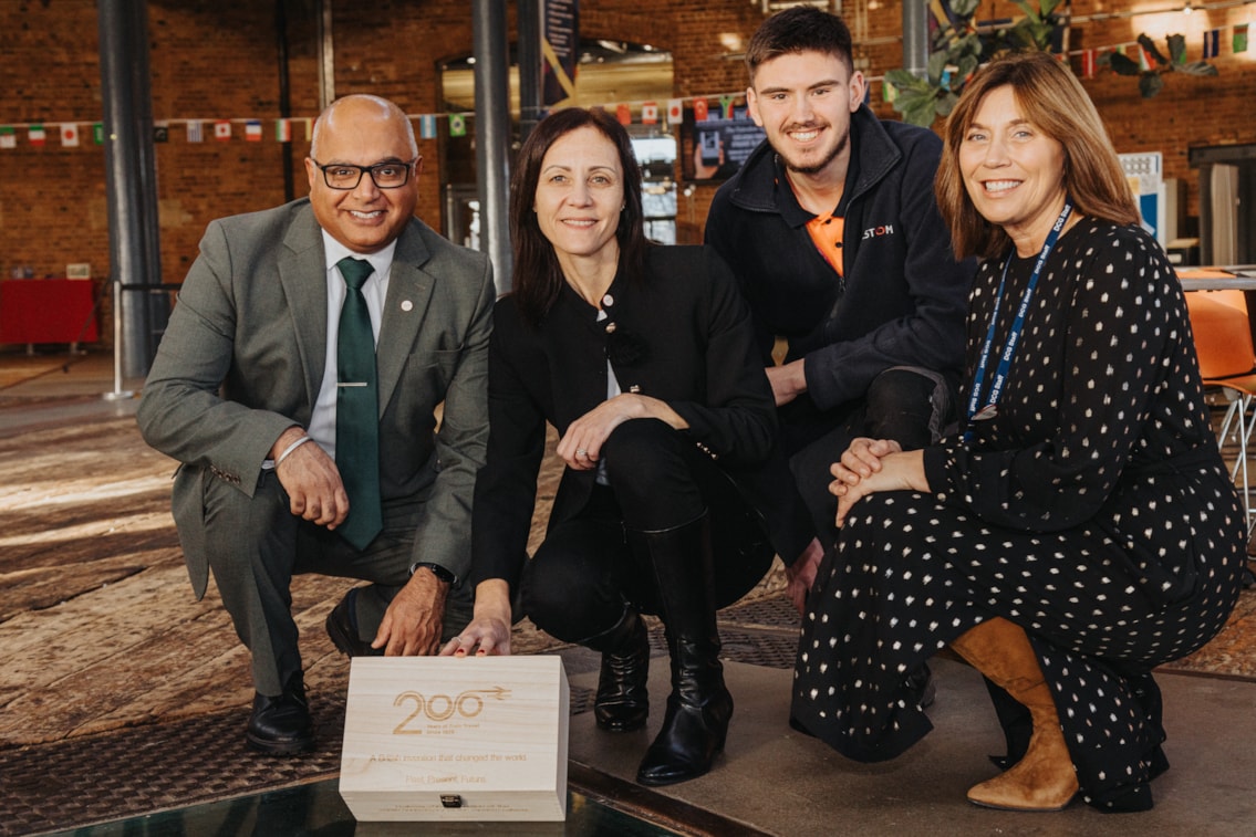 L-R Baggy Shanker, Emma Roberts, Jack Rhodes and Heather Kelly, kneeling next to the glass-covered, underground recess where the time capsule will be stored