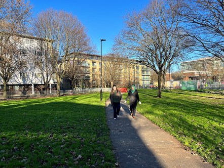 Two people walk in Bingfield Park