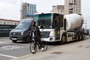 TfL Image - A cyclist waiting at a traffic light within an advanced stop line, in front of a van and a mixer with a direct vision cab