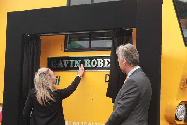 Gavin's partner Meg Williamson touches the plaque as Network Rail's chief executive Mark Carne watches on