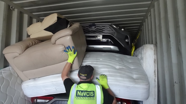 NaVCIS officer in container with suspected stolen vehicles-2