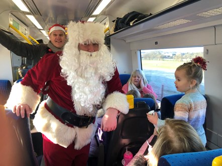 This image shows Father Christmas spreading festive cheer on a Northern train