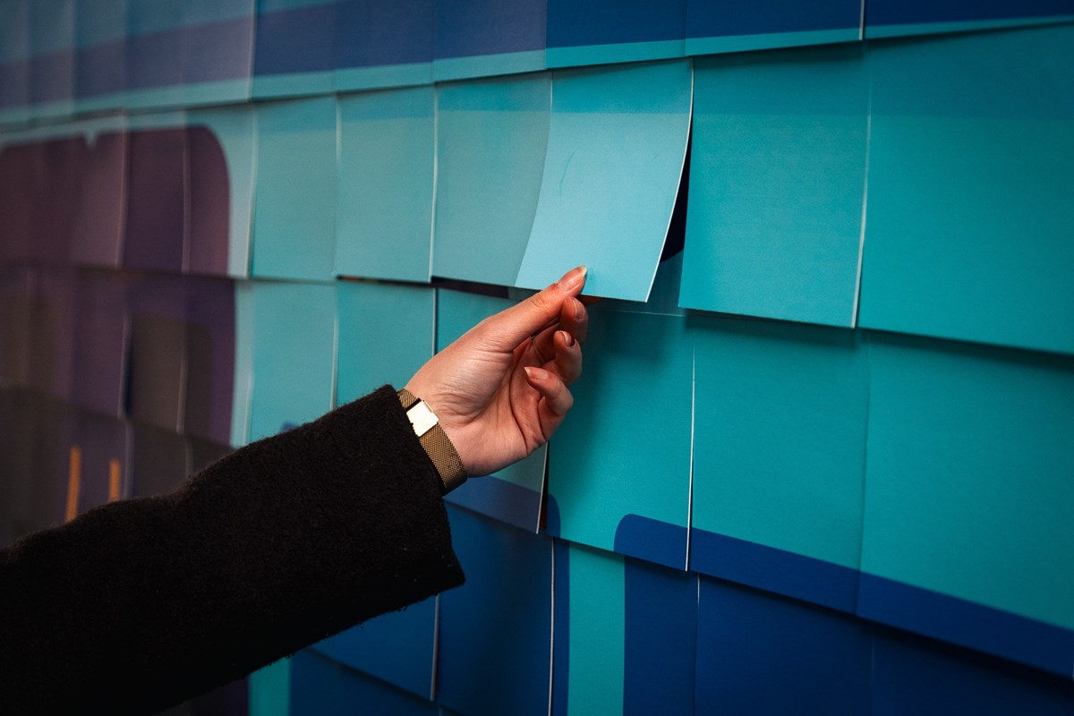 Image shows customer taking a ticket from the billboard