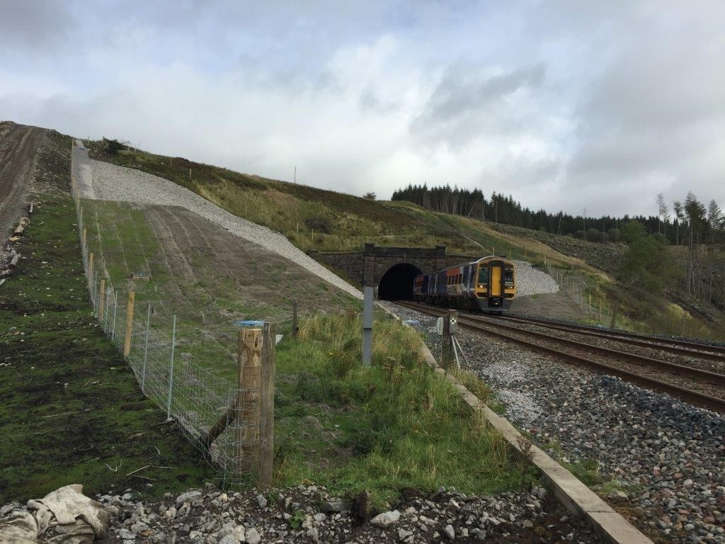 A Northern train travels along the Settle and Carlisle line past the drainage work at Dent, Cumbria