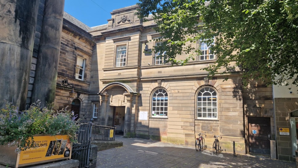 Lancaster library building is light stone in colour with large white framed windows and two bikes outside
