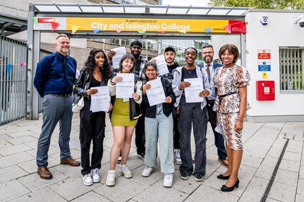 City & Islington College students including Gabi, third from left, and Salma, fourth from left in the front row, celebrate with Cllr Michelline Ngongo, right, Islington's Corporate Director of Children's Services Jon Abbey, left, and college staff