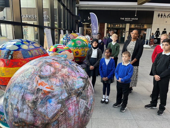 The World Reimagined: The World Reimagined learning programme manager, Sabrina Reid with children from Leeds schools who have made the globes now on display at Leeds train station.