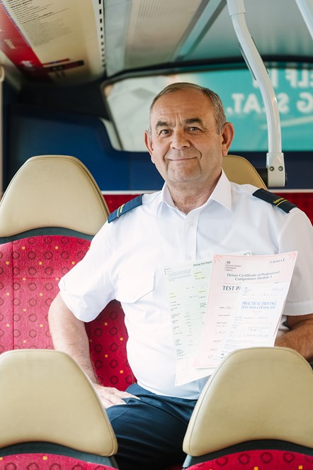 A driver displays his licence to drive buses