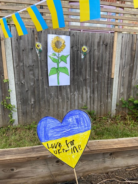A raised bed displays hearts in the colours of the Ukraine flag with messages of solidarity, at Christ The King Catholic Primary School-4