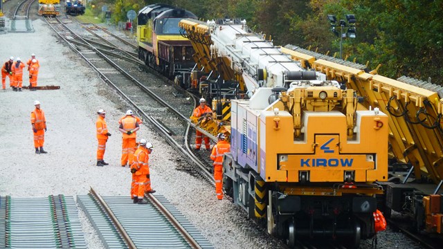 Passengers reminded to ‘travel either side’ of Early May Bank Holiday: Library image of a train-mounted crane laying panels of railway track