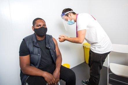 A man is vaccinated against Covid-19 in Islington; picture taken at Emirates Stadium vaccination event in June 2021: Picture of a man being vaccinated against Covid-19 in Islington