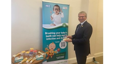 Councillor Michael Green shows off the promotional Lets Get Brushing stand at County Hall, Preston