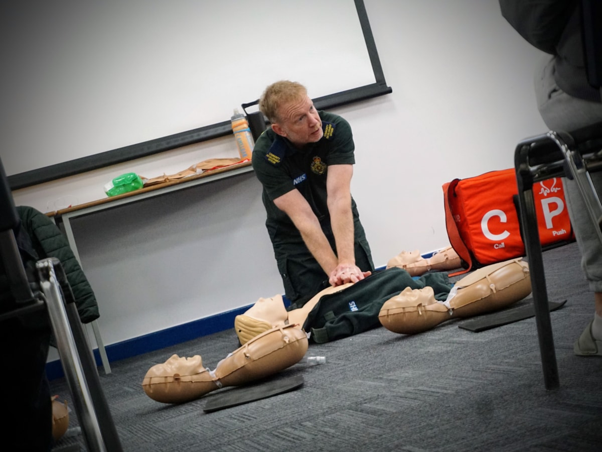 Paul Brolly, kneeling, performing CRP on dummy