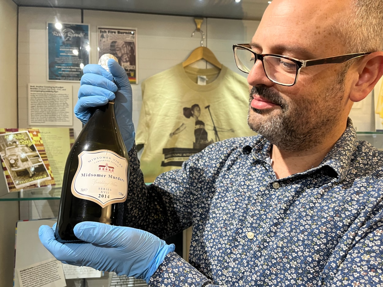 Literature in Leeds: Curator Patrick Bourne with a wine bottle from the set of celebrated bucolic British crime drama Midsomer Murders, on loan from screenwriter and playwright Lisa Holdsworth who has also worked on hit shows including Call the Midwife and Fat Friends.