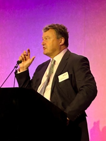 Andrew Miller BVRLA Fleets in Charge 2023 no.1: Motability Operations Chief Executive Andrew Miller speaking at the podium on-stage at the BVRLA's Fleets in Charge 2023 Conference.