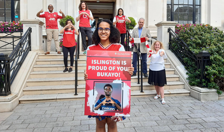 Islington Council leader Cllr Kaya Comer-Schwartz with a card saying "Islington is proud of you, Bukayo!", with  Cllrs Ibrahim, Ozdemir, Bell-Bradford, Khondoker, Convery and O'Halloran in the background