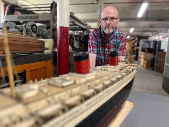 Model ships: Curator John McGoldrick with a scale replica of the famed cruise liner the RMS Queen Elizabeth. More than a metre-and-a-half long, the model is a tribute to the much larger original, which was once the biggest passenger ship ever built at more than a thousand feet in length.
Made in Clydebank, Scotland, and launched in 1938, the full-sized ship was operated by Cunard Line and provided a weekly transatlantic service between Southampton and New York City.