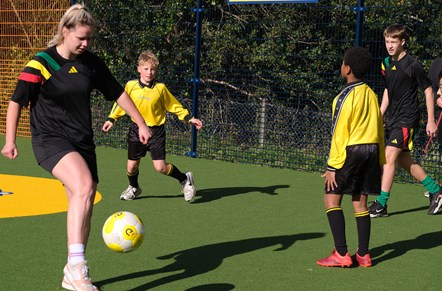 Boys and girls playing football on the Cruyff Court