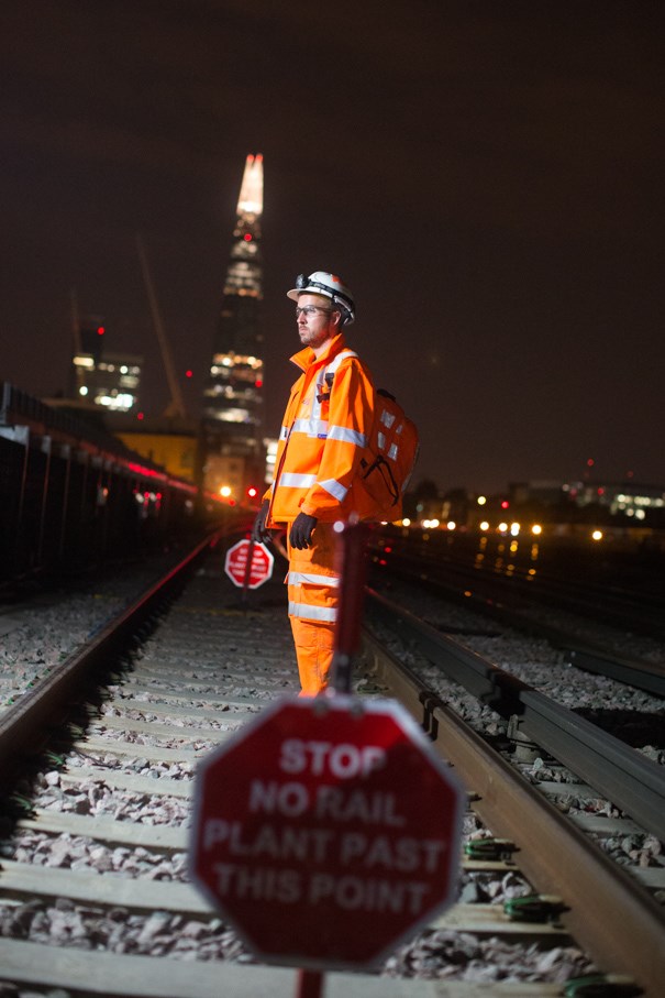Stunning night time shot of a Network Rail engineer working on track as part of the rebuilding of London Bridge station, with the Shard lit up in the background.: Stunning night time shot of a Network Rail engineer working on track as part of the rebuilding of London Bridge station, with the Shard lit up in the background.